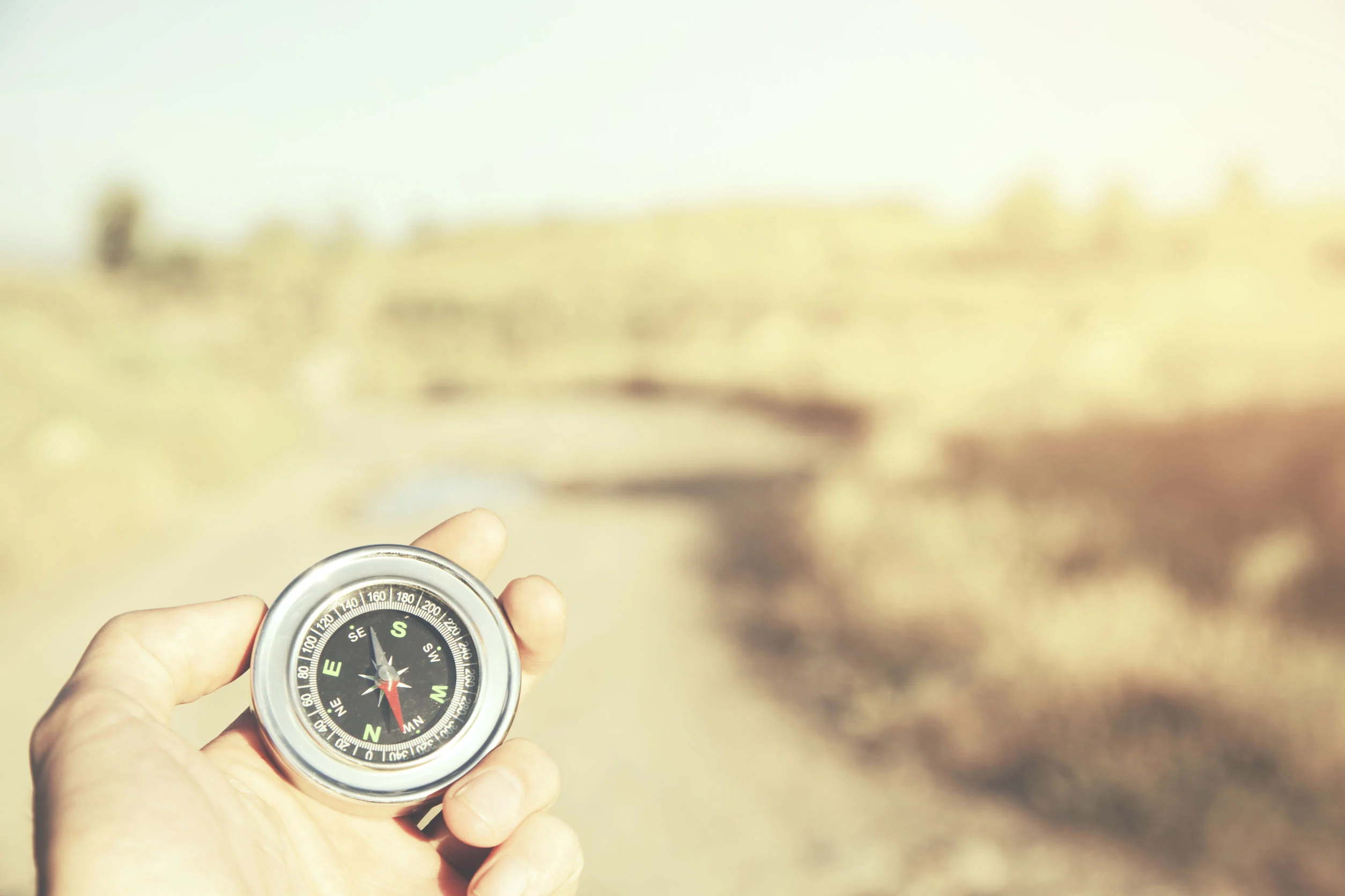 68899165 - hand man holding compass navigator on road way