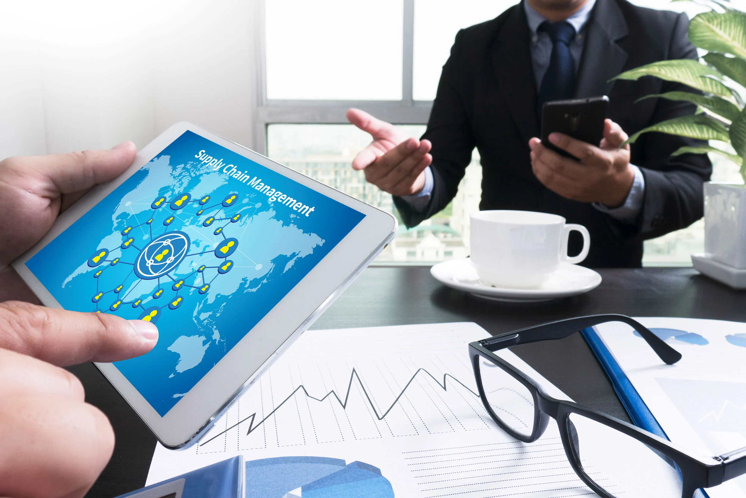 61609485_l Business team reviewing global supply chain data on a tablet