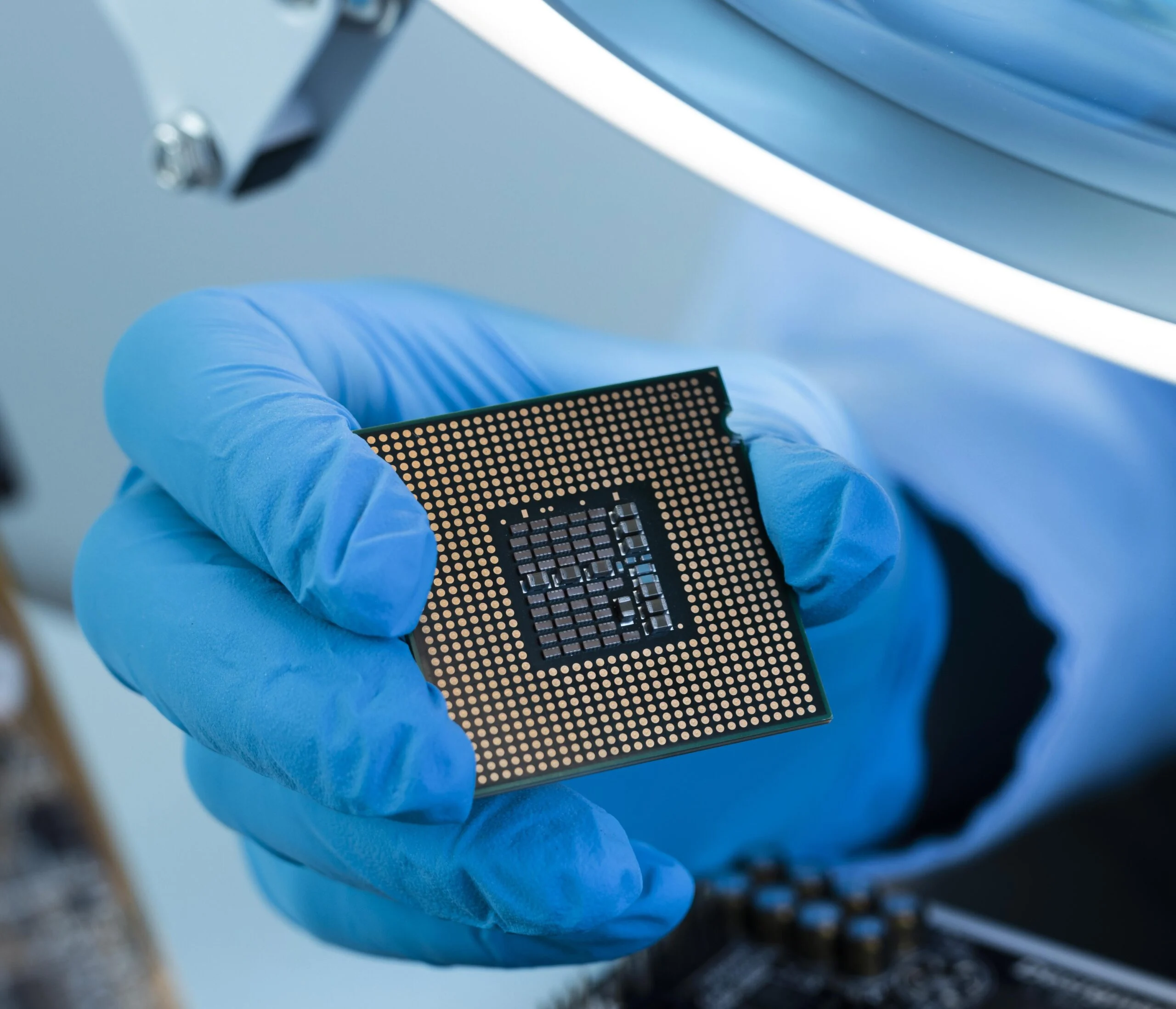 close-up-hand-with-glove-holding-chip Gloved hand holding a microchip
