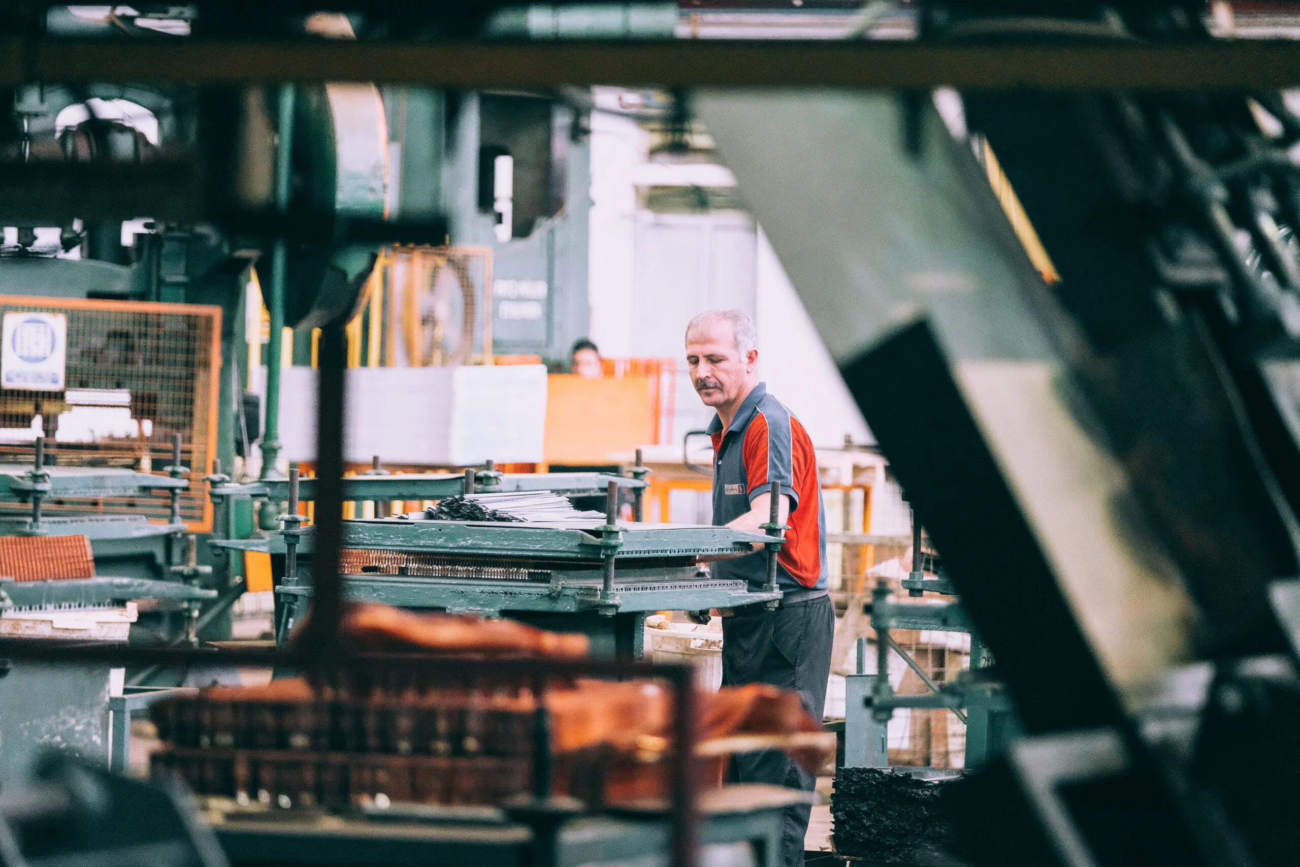 sam-moghadam-khamseh-bN_aaTKfwM0-unsplash Worker operating industrial machinery