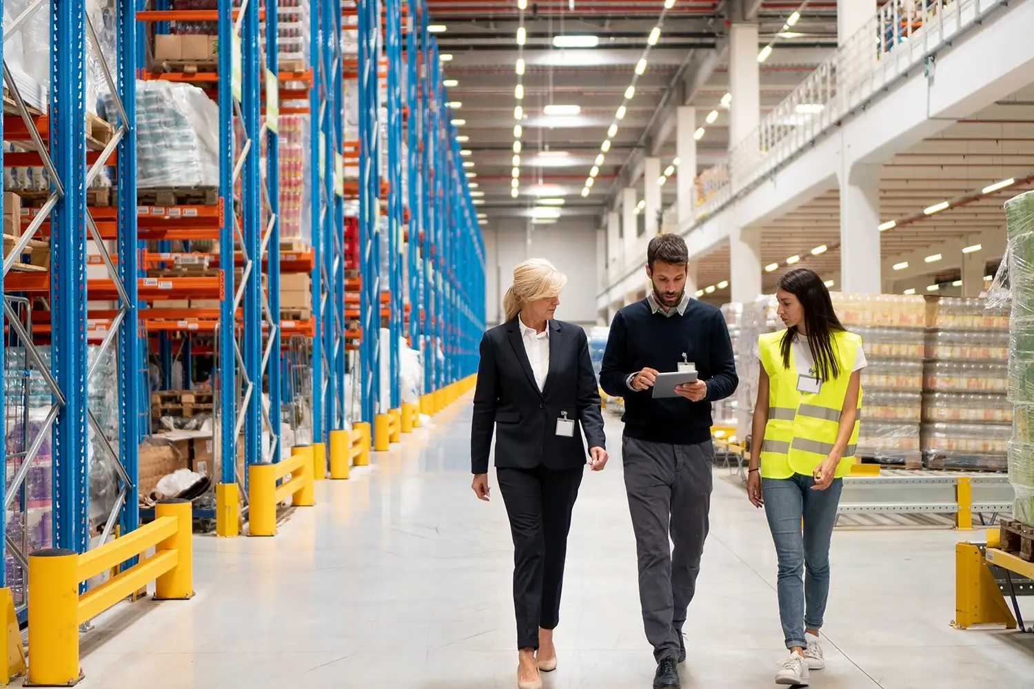 Two lean consultants speaking with a smart warehousing staff member at the facility