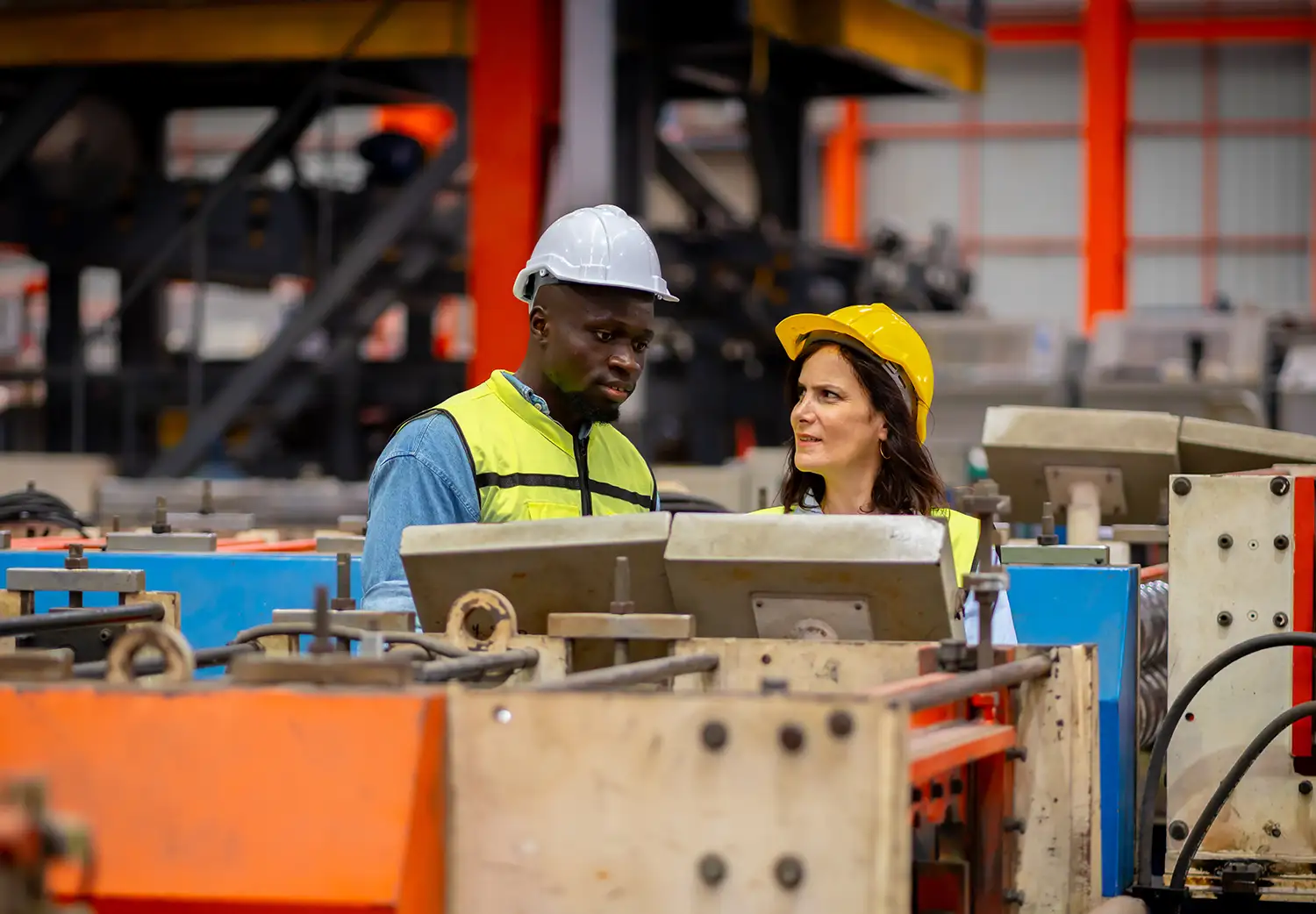 Two people in a manufacturing facility examining ways to improve productivity using digital tools.